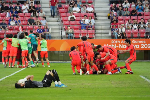 (261003) -- TOYOTA, Oct. 3, 2026 (Xinhua) -- Players of China celebrate after winning the men's 3rd place match of football between China and Uzbekistan at 20th Asian Games Aichi-Nagoya 2026 in Toyota of Aichi Prefecture, Japan, Oct. 3, 2026. (Xinhua/Lui Siu Wai)