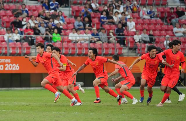 (261003) -- TOYOTA, Oct. 3, 2026 (Xinhua) -- Players of China celebrate after winning the men's 3rd place match of football between China and Uzbekistan at 20th Asian Games Aichi-Nagoya 2026 in Toyota of Aichi Prefecture, Japan, Oct. 3, 2026. (Xinhua/Lui Siu Wai)
