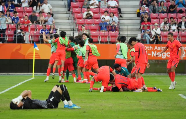 (261003) -- TOYOTA, Oct. 3, 2026 (Xinhua) -- Players of China celebrate after winning the men's 3rd place match of football between China and Uzbekistan at 20th Asian Games Aichi-Nagoya 2026 in Toyota of Aichi Prefecture, Japan, Oct. 3, 2026. (Xinhua/Lui Siu Wai)