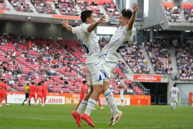 (261003) -- TOYOTA, Oct. 3, 2026 (Xinhua) -- Uzbekistan's Shodiyor Shodiboev (R) celebrates his goal during the men's 3rd place match of football between China and Uzbekistan at 20th Asian Games Aichi-Nagoya 2026 in Toyota of Aichi Prefecture, Japan, Oct. 3, 2026. (Xinhua/Lui Siu Wai)