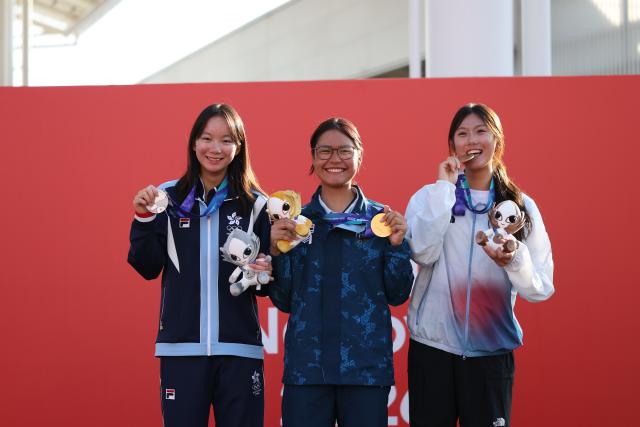 (261003) -- GAMAGORI, Oct. 3, 2026 (Xinhua) -- Gold medalist Pinchanok Klaysomboon (C) of Thailand, silver medalist Huang Zixi (L) of China's Hong Kong and bronze medalist Lee Songha of South Korea pose during the awarding ceremony for the Girls' Dinghy of Sailing at the 20th Asian Games Aichi-Nagoya 2026 in Gamagori of Aichi Prefecture, Japan, Oct. 3, 2026. (Xinhua/Deng Hua)