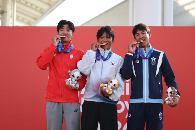 (261003) -- GAMAGORI, Oct. 3, 2026 (Xinhua) -- Gold medalist Choi Jiun (C) of South Korea, silver medalist Goh Ian (L) of Singapore and bronze medalist Cheng De Villemor Salgado Tiago of China's Hong Kong pose during the awarding ceremony for the Boys' Dinghy of Sailing at the 20th Asian Games Aichi-Nagoya 2026 in Gamagori of Aichi Prefecture, Japan, Oct. 3, 2026. (Xinhua/Deng Hua)