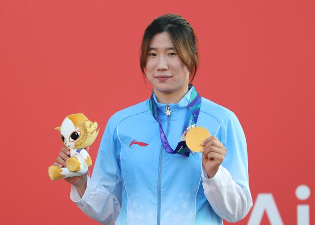 (261003) -- GAMAGORI, Oct. 3, 2026 (Xinhua) -- Gold medalist Li Wenqi of China poses during the awarding ceremony for the Women's Windsurfing of Sailing at the 20th Asian Games Aichi-Nagoya 2026 in Gamagori of Aichi Prefecture, Japan, Oct. 3, 2026. (Xinhua/Deng Hua)