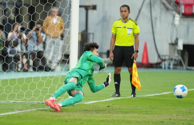 (261003) -- TOYOTA, Oct. 3, 2026 (Xinhua) -- Goalkeeper Li Hao of China dives to save a penalty shot during the penalty shootout of the men's 3rd place match of football between China and Uzbekistan at 20th Asian Games Aichi-Nagoya 2026 in Toyota of Aichi Prefecture, Japan, Oct. 3, 2026. (Xinhua/Lui Siu Wai)