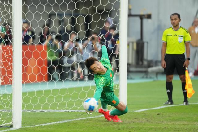 (261003) -- TOYOTA, Oct. 3, 2026 (Xinhua) -- Goalkeeper Li Hao of China dives to save a penalty shot during the penalty shootout of the men's 3rd place match of football between China and Uzbekistan at 20th Asian Games Aichi-Nagoya 2026 in Toyota of Aichi Prefecture, Japan, Oct. 3, 2026. (Xinhua/Lui Siu Wai)
