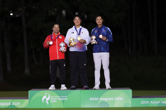 (261003) -- KASUGAI, Oct. 3, 2026 (Xinhua) -- Gold medalist Kim Joohyung of South Korea, silver medalist Higa Kazuki of Japan and bronze medalist Kaewkanjana Sadom of Thailand pose during the awarding ceremony for the Men's Individual Stroke Play of Golf at 20th Asian Games Aichi-Nagoya 2026 in Kasugai of Aichi Prefecture, Japan, Oct. 3, 2026. (Xinhua/Li Bo)