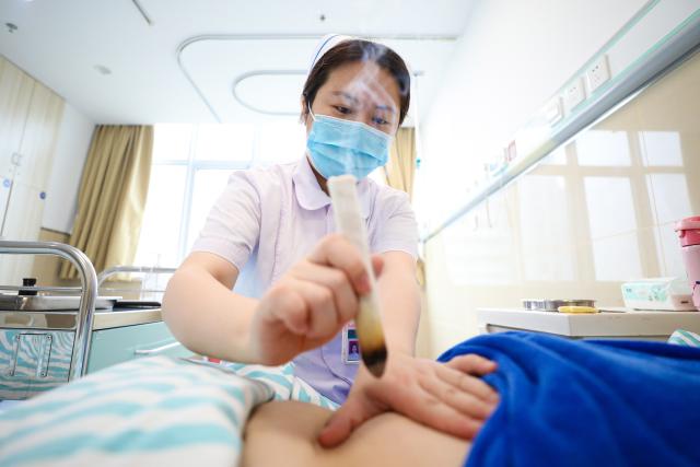 (261003) -- BEIJING, Oct. 3, 2026 (Xinhua) -- A nurse performs moxibustion therapy to a patient at a Traditional Chinese Medicine (TCM) hospital in Hai'an, east China's Jiangsu Province, Oct. 3, 2026.
  Many medical workers remain at their posts during the National Day holiday to provide healthcare services and safeguard public health. (Photo by Gu Binbin/Xinhua)