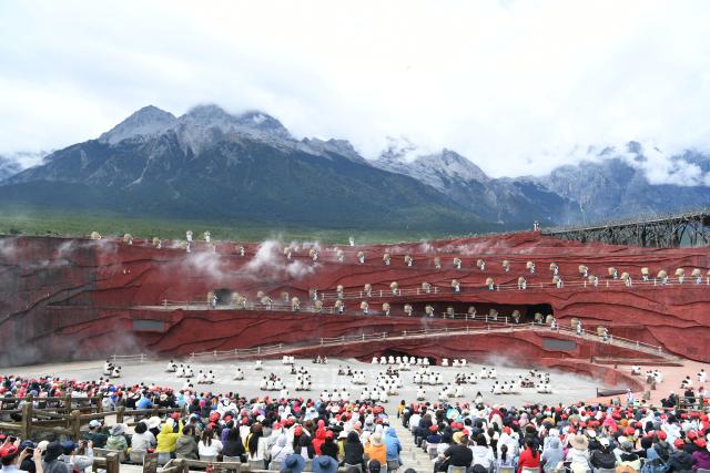 (261003) -- BEIJING, Oct. 3, 2026 (Xinhua) -- Tourists watch the outdoor musical "Impression Lijiang" at the Yulong Snow Mountain scenic spot in Lijiang, southwest China's Yunnan Province, Oct. 3, 2026.
  China's cultural and tourism market is thriving during this year's National Day holiday, with a wide range of options including scenic getaways, autumn outings, tourism with revolutionary topics, nighttime entertainment, and cultural tours featuring the country's intangible cultural heritage. (Photo by Zhao Qingzu/Xinhua)