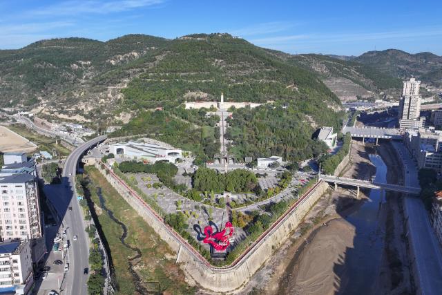 (261003) -- WUQI, Oct. 3, 2026 (Xinhua) -- A drone photo taken on Oct. 2, 2026 shows a view of the Shengli Mountain in Wuqi County of Yan'an City, northwest China's Shaanxi Province.
  The year 2026 marks the 90th anniversary of the victory of the Central Red Army's Long March. Wuqi is the county where the Long March ended. Today, the county is home to many revolutionary sites. 
   The Long March was an epic military trek from 1934 to 1936, during which the Communist Party of China-led Red Army broke through encirclement by the Kuomintang forces. Red Army soldiers braved raging rivers, snow-covered mountains and treacherous grasslands, with some marching as far as 12,500 kilometers. The maneuver helped lay the foundation for the eventual victory of the Chinese revolution.
   The spirit of the Long March has been passed down through generations in Wuqi, inspiring local people to forge ahead and pursue development.        
   In the past, the county had long suffered from fragile environment, severe desertification and natural disasters. Since launching large-scale ecological restoration efforts in 1998, the county has seen its forest and grass coverage rate rise from 19.6 percent in 1997 to 72.9 percent at present, bringing significant improvements to the local environment. 
   Meanwhile, Wuqi has actively developed its apple industry. The apple orchards now cover 120,000 mu (about 8,000 hectares), helping increase farmers' incomes and promote rural revitalization. (Xinhua/Zou Jingyi)