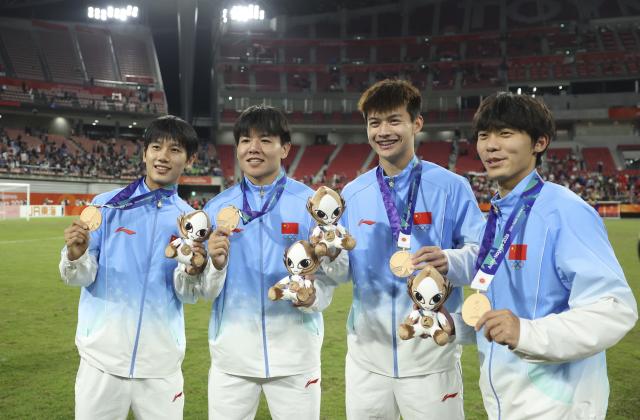(261003) -- TOYOTA, Oct. 3, 2026 (Xinhua) -- Players of team China pose for photos after the awarding ceremony for men's football event at 20th Asian Games Aichi-Nagoya 2026 in Toyota of Aichi Prefecture, Japan, Oct. 3, 2026. (Xinhua/Jia Haocheng)