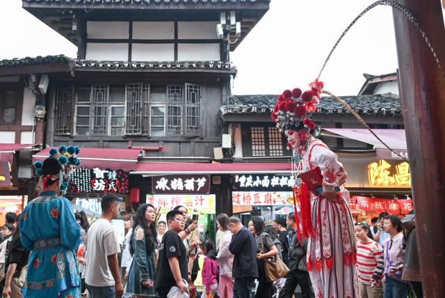 (261003) -- BEIJING, Oct. 3, 2026 (Xinhua) -- Tourists visit the Ciqikou ancient town in southwest China's Chongqing Municipality on Oct. 3, 2026.
  China's cultural and tourism market is thriving during this year's National Day holiday, with a wide range of options including scenic getaways, autumn outings, tourism with revolutionary topics, nighttime entertainment, and cultural tours featuring the country's intangible cultural heritage. (Xinhua/Chen Cheng)