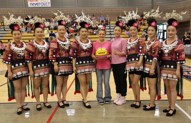 (261003) -- WASHINGTON, Oct. 3, 2026 (Xinhua) -- Members of "Auntie Basketball" pose for a group photo with an American student at Crimson Cliffs High School in Washington, Utah, the United States, Oct. 2, 2026.
  TO GO WITH "Feature: 'Auntie Basketball' brings Chinese culture to Utah high school" (Photo by Zeng Hui/Xinhua)