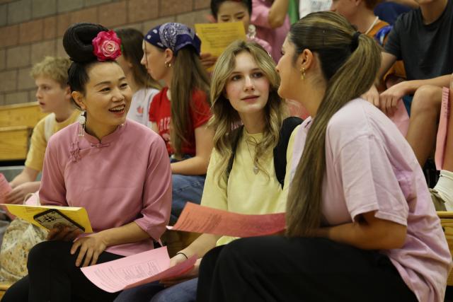 (261003) -- WASHINGTON, Oct. 3, 2026 (Xinhua) -- A member of "Auntie Basketball" talks with American students at Crimson Cliffs High School in Washington, Utah, the United States, Oct. 2, 2026.
  TO GO WITH "Feature: 'Auntie Basketball' brings Chinese culture to Utah high school" (Photo by Zeng Hui/Xinhua)