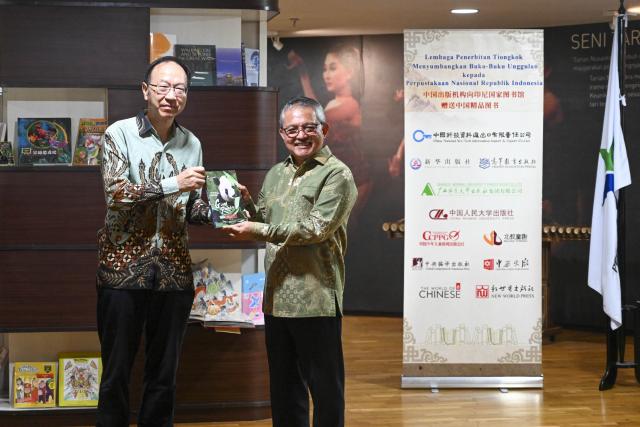 (261003) -- JAKARTA, Oct. 3, 2026 (Xinhua) -- Wang Siping (L), cultural counselor of the Chinese Embassy in Indonesia and Director of the National Library of Indonesia E. Aminudin Aziz pose for a photo during a handover ceremony of books from Chinese publishing houses to National Library of Indonesia in Jakarta, Indonesia, Oct. 3, 2026.
  The National Library of Indonesia received a donation of 100 books from 11 Chinese publishing houses during a handover ceremony held here on Saturday. (Xinhua/Zulkarnain)