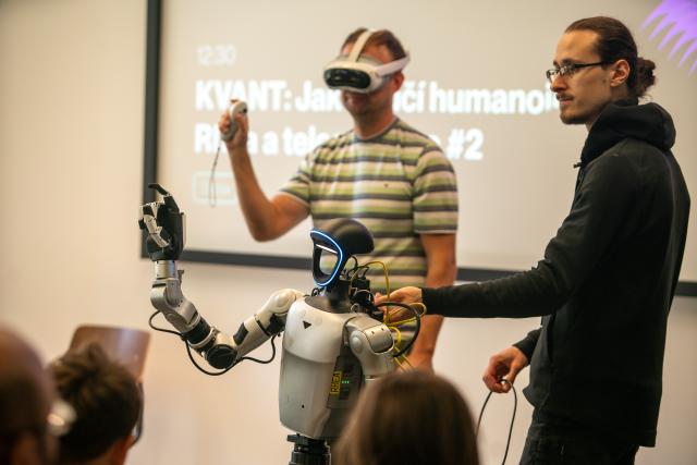 (261003) -- PRAGUE, Oct. 3, 2026 (Xinhua) -- A humanoid robot imitates the movements of a human operator (back) during a live demonstration at the Prague Innovation Week in Prague, the Czech Republic, Oct. 3, 2026. Prague Innovation Week was held in the Czech capital Prague from October 1 to 3. (Photo by Dana Kesnerova/Xinhua)