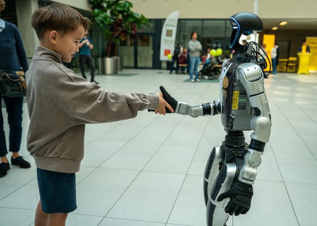 (261003) -- PRAGUE, Oct. 3, 2026 (Xinhua) -- A boy shakes hands with a humanoid robot at the Prague Innovation Week in Prague, the Czech Republic, Oct. 3, 2026. Prague Innovation Week was held in the Czech capital Prague from October 1 to 3. (Photo by Dana Kesnerova/Xinhua)