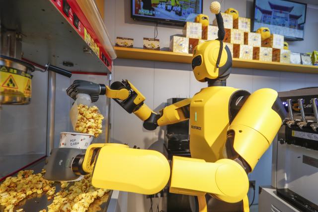 (261004) -- HEFEI, Oct. 4, 2026 (Xinhua) -- A robot makes popcorn at a store in Tunxi District of Huangshan, east China's Anhui Province, Oct. 1, 2026. During the National Day holiday, embodied AI robots of various functions rolled out in commercial and cultural blocks have been a major attraction for tourists. Through smart interactions, they have diversified tourism offerings and experiences. (Photo by Shi Yalei/Xinhua)