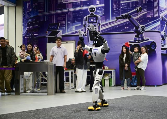 (261004) -- HEFEI, Oct. 4, 2026 (Xinhua) -- A robot dances in a public venue in Hefei, east China's Anhui Province, Oct. 3, 2026. During the National Day holiday, embodied AI robots of various functions rolled out in commercial and cultural blocks have been a major attraction for tourists. Through smart interactions, they have diversified tourism offerings and experiences. (Xinhua/Zhou Mu)