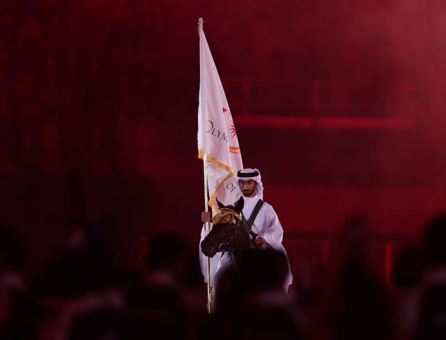 (261004) -- NAGOYA, Oct. 4, 2026 (Xinhua) -- Jassim Al Kuwari of Qatar holds the flag of Olympic Council of Asia (OCA) on a horse during the closing ceremony of the 20th Asian Games Aichi-Nagoya 2026 in Nagoya, Japan, Oct. 4, 2026. (Xinhua/Jia Haocheng)