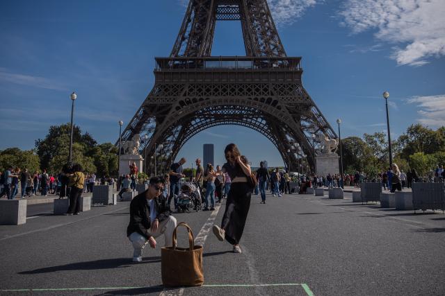 (261004) -- PARIS, Oct. 4, 2026 (Xinhua) -- Chinese tourists take a selfie in front of the Eiffel Tower in Paris, France, on Oct. 3, 2026. Paris has witnessed a large number of Chinese tourists who have chosen outbound trips during China's National Day holiday. (Photo by Aurelien Morissard/Xinhua)