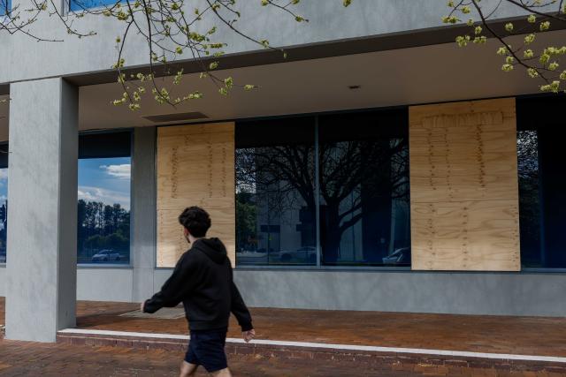 (261004) -- CANBERRA, Oct. 4, 2026 (Xinhua) -- Wooden boards are nailed over damaged windows of a government building in Canberra, Australia, on Oct. 4, 2026. Australian police said on Sunday they are investigating damage to two government buildings in Canberra after ball bearings were allegedly used to strike windows at the properties.
   TO GO WITH "Australian police investigate damage to gov't buildings in Canberra" (Photo by Chu Chen/Xinhua)