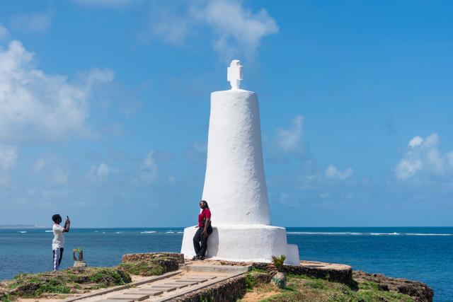 (261004) -- MALINDI, Oct. 4, 2026 (Xinhua) -- A woman poses for photos in front of a monument in Malindi, Kilifi County, Kenya, Oct. 4, 2026. Malindi, located on Kenya's southeastern coast along the Indian Ocean, is a historic city in Kilifi County and one of East Africa's well-known coastal tourist destinations. (Xinhua/Xie Jianfei)