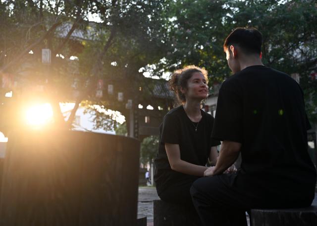 (261004) -- WENXIAN, Oct. 4, 2026 (Xinhua) -- Gilda Fongaro (L), a Taijiquan enthusiast from Italy, teaches her husband Yang Kaifan Italian in Chenjiagou Village of Wenxian County, central China's Henan Province, Aug. 25, 2026. Social media users in the West have recently embraced "Chinamaxxing," in which young people show interest in aspects of Chinese daily life.
   Taijiquan, a kind of traditional martial arts, was born in the mid-17th century in Chenjiagou Village. Rooted in Chinese philosophy, traditional medicine and martial arts, Taijiquan has evolved into a wide range of styles and is now practiced in more than 180 countries and regions. For foreign visitors, Chenjiagou is naturally one of the best spots to experience the "Chinamaxxing" trend. The small village offers a tranquil and comfortable living environment which lets visitors get away from the busy pace of city life and immerse themselves in traditional Chinese culture. (Xinhua/Li Jianan)