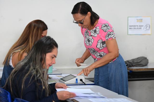 (261004) -- BRASILIA, Oct. 4, 2026 (Xinhua) -- A voter verifies her identity at a polling station in Brasilia, Brazil, Oct. 4, 2026. Voting in the first round of Brazil's 2026 presidential election officially began at 8 a.m. (1100 GMT) on Sunday, with polling stations across the country scheduled to close at 5 p.m. (0800 GMT).
   Initial results are expected to be announced within a few hours after the polls close. (Photo by Lucio Tavora/Xinhua)