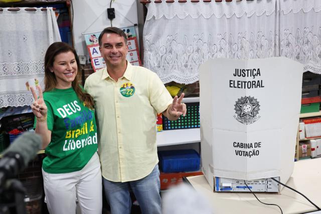 (261004) -- BRASILIA, Oct. 4, 2026 (Xinhua) -- Flavio Bolsonaro (R), presidential candidate of Brazil's Liberal Party, poses for photos with his wife after casting his ballot at a polling station in Rio de Janeiro, Brazil, Oct. 4, 2026. Voting in the first round of Brazil's 2026 presidential election officially began at 8 a.m. (1100 GMT) on Sunday, with polling stations across the country scheduled to close at 5 p.m. (0800 GMT).
   Initial results are expected to be announced within a few hours after the polls close. (Xinhua/Jin Haoyuan)