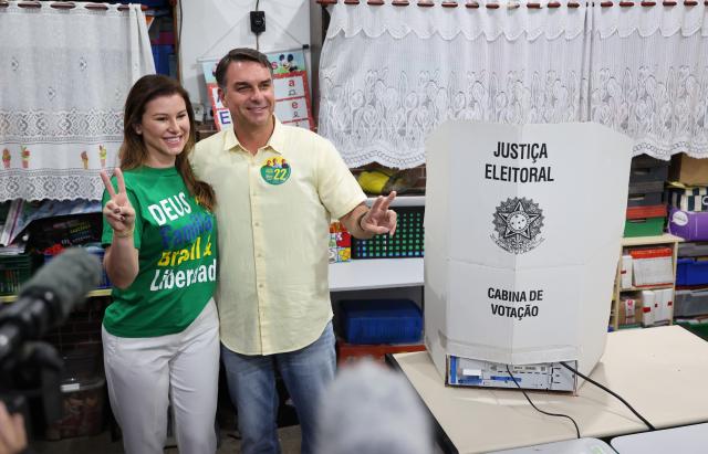 (261004) -- BRASILIA, Oct. 4, 2026 (Xinhua) -- Flavio Bolsonaro (R), presidential candidate of Brazil's Liberal Party, poses for photos with his wife after casting his ballot at a polling station in Rio de Janeiro, Brazil, Oct. 4, 2026. Voting in the first round of Brazil's 2026 presidential election officially began at 8 a.m. (1100 GMT) on Sunday, with polling stations across the country scheduled to close at 5 p.m. (0800 GMT).
   Initial results are expected to be announced within a few hours after the polls close. (Xinhua/Jin Haoyuan)
