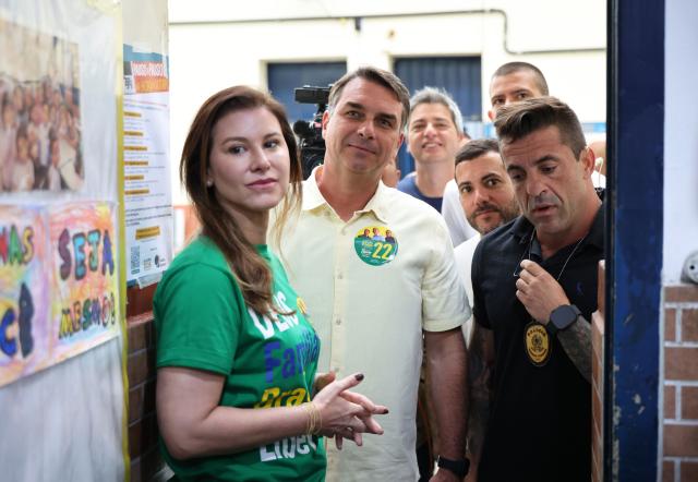 (261004) -- BRASILIA, Oct. 4, 2026 (Xinhua) -- Flavio Bolsonaro (2nd L), presidential candidate of Brazil's Liberal Party, is seen with his wife (1st L) at a polling station in Rio de Janeiro, Brazil, Oct. 4, 2026. Voting in the first round of Brazil's 2026 presidential election officially began at 8 a.m. (1100 GMT) on Sunday, with polling stations across the country scheduled to close at 5 p.m. (0800 GMT).
   Initial results are expected to be announced within a few hours after the polls close. (Xinhua/Jin Haoyuan)