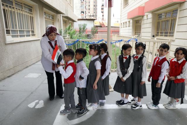 (261004) -- BAGHDAD, Oct. 4, 2026 (Xinhua) -- Primary school students return to school on the first day of new academic year in Baghdad, Iraq, Oct. 4, 2026. The new academic year officially began in schools across Iraq on Sunday. (Xinhua/Khalil Dawood)