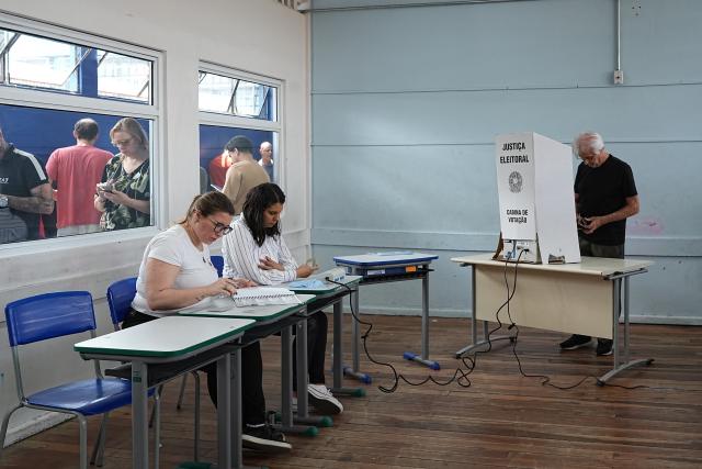 (261004) -- SAO PAULO, Oct. 4, 2026 (Xinhua) -- A voter (R) casts his ballot at a polling station in Sao Bernardo do Campo, Sao Paulo state, Brazil, Oct. 4, 2026. Voting in the first round of Brazil's 2026 presidential election officially began at 8 a.m. (1100 GMT) on Sunday, with polling stations across the country scheduled to close at 5 p.m. (0800 GMT). Initial results are expected to be announced within a few hours after the polls close. (Photo by Paulo Lopes/Xinhua)