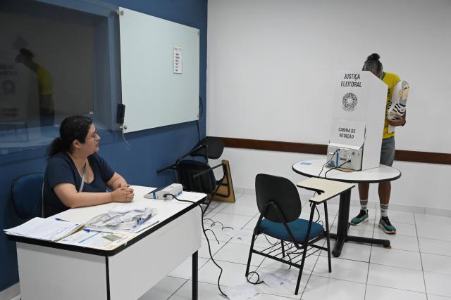 (261004) -- BRASILIA, Oct. 4, 2026 (Xinhua) -- A voter (R) casts his ballot at a polling station in Brasilia, Brazil, Oct. 4, 2026. Voting in the first round of Brazil's 2026 presidential election officially began at 8 a.m. (1100 GMT) on Sunday, with polling stations across the country scheduled to close at 5 p.m. (0800 GMT). Initial results are expected to be announced within a few hours after the polls close. (Photo by Lucio Tavora/Xinhua)