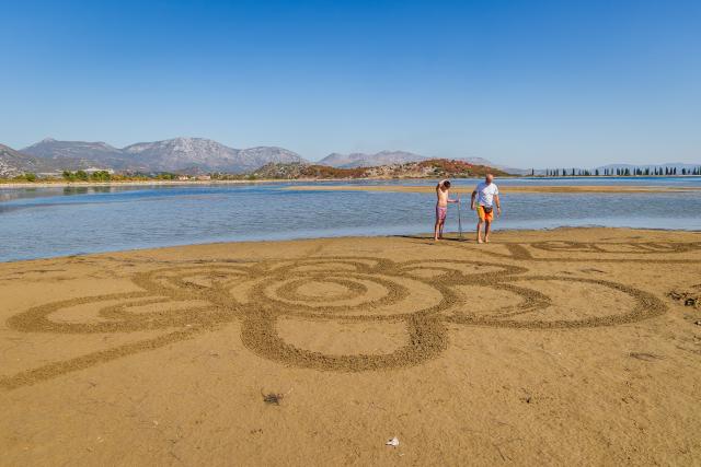 (261004) -- ZAGREB, Oct. 4, 2026 (Xinhua) -- Two artists create a sand art drawing during a sand art festival in the Neretva River Estuary, Croatia, on Oct. 4, 2026. (Zvonimir Barisin/Pixsell via Xinhua)