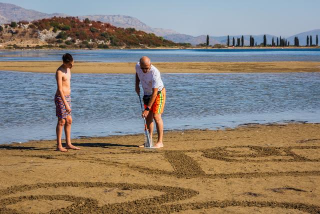 (261004) -- ZAGREB, Oct. 4, 2026 (Xinhua) -- Two artists create a sand art drawing during a sand art festival in the Neretva River Estuary, Croatia, on Oct. 4, 2026. (Zvonimir Barisin/Pixsell via Xinhua)