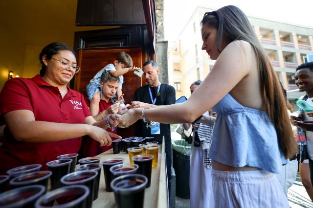 (261005) -- MARINO, Oct. 5, 2026 (Xinhua) -- Customers buy wine at a wine stand during the Grape Festival of Marino 2026 in Marino, Italy, Oct. 4, 2026. (Xinhua/Wang Kaiyan)
