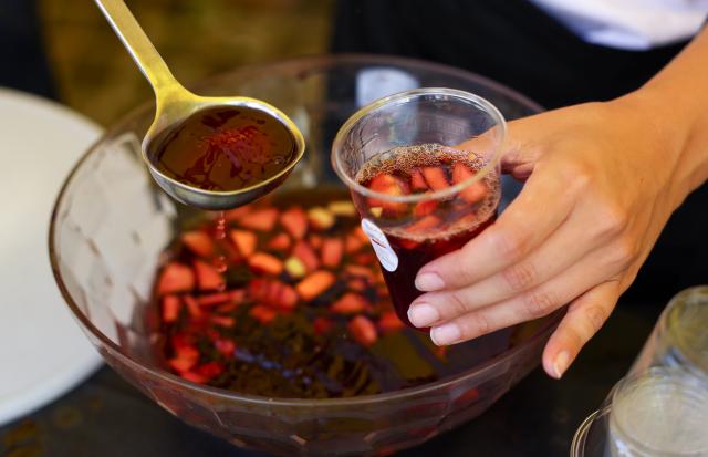 (261005) -- MARINO, Oct. 5, 2026 (Xinhua) -- A vendor makes Sangria at a wine stand during the Grape Festival of Marino 2026 in Marino, Italy, Oct. 4, 2026. (Xinhua/Wang Kaiyan)