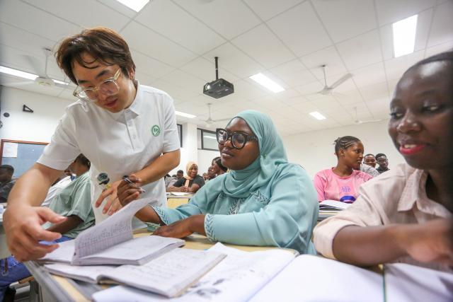 (261005) -- DAR ES SALAAM, Oct. 5, 2026 (Xinhua) -- Chinese volunteer teacher Liu Mu guides a student during a class at the Confucius Institute at the University of Dar es Salaam in Dar es Salaam, Tanzania, Oct. 1, 2026.
  As the world prepares to mark World Teachers' Day on Oct. 5, Chinese and Tanzanian educators are joining forces to expand Chinese language education in Tanzania, blending native linguistic expertise with localized cultural insights.
   TO GO WITH "Roundup: Chinese, Tanzanian educators join forces to boost Chinese language education" (Xinhua/Emmanuel Herman)