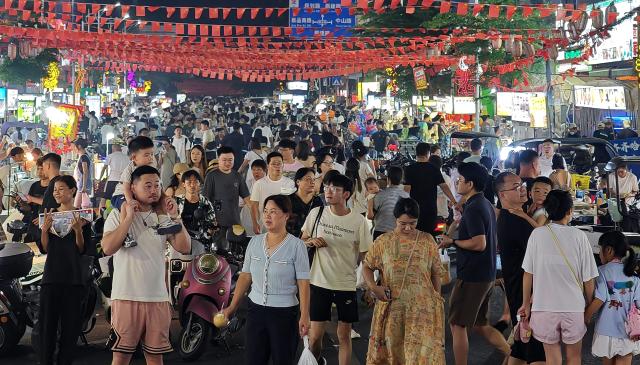 (261005) -- HAIKOU, Oct. 5, 2026 (Xinhua) -- This photo taken on Oct. 1, 2026 shows the bustling night market in Xincun Port of Lingshui Li Autonomous County, south China's Hainan Province.
  During the first National Day holiday since the launch of the island-wide special customs operations at Hainan Free Trade Port (FTP), the tropical island has offered visitors from home and abroad a diverse range of experiences -- from duty-free shopping and local food to historic neighborhoods and the distinctive lifestyle of fishing communities.
   TO GO WITH "Across China: China's island province Hainan offers diverse tourism experiences to holidaymakers" (Xinhua/Guo Cheng)