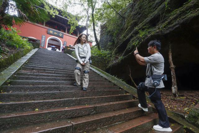 (261005) -- HUANGSHAN, Oct. 5, 2026 (Xinhua) -- Tourists wearing exoskeleton robots hike in the Qiyun Mountain scenic area of Xiuning County, Huangshan City, east China's Anhui Province, Oct. 2, 2026.
  The Qiyun Mountain scenic area offers exoskeleton robot rentals during the National Day holiday to help visitors hike with less effort. 
  The lightweight, easy-to-use devices sense body movements, providing uphill assistance and downhill cushioning to protect knees and reduce leg strain. 
  With a growing number of hikers in recent years, the area now offers over 20 such robots, using technology to deliver a smarter mountain climbing experience. (Photo by Shi Yalei/Xinhua)