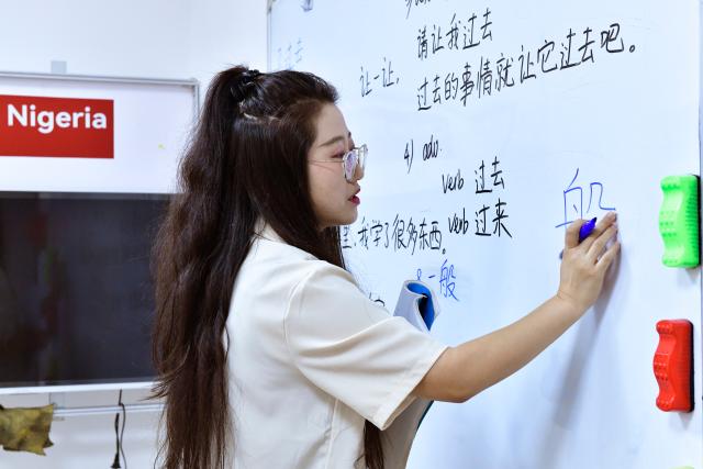 (261005) -- ABUJA, Oct. 5, 2026 (Xinhua) -- Chinese teacher Qiu Nan from the Confucius Institute at Nnamdi Azikiwe University teaches local students at a teaching site in Abuja, Nigeria, Sept. 30, 2026. October 5 marks World Teachers' Day. Over the years, Confucius Institutes across Africa have actively promoted Chinese language education and cultural exchange, playing an important role in fostering mutual learning between China and African countries and strengthening friendship between the Chinese and African peoples. (Xinhua/Hong Zehua)