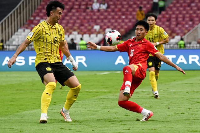 (261005) -- JAKARTA, Oct. 5, 2026 (Xinhua) -- Quentin Cheng (L) of Malaysia vies with Ngo Dang Khoa of Vietnam during the FIFA ASEAN Cup 2026 Division 1 Bronze Final Match between Malaysia and Vietanm at Gelora Bung Karno Stadium in Jakarta, Indonesia, Oct. 5, 2026. (Xinhua/Agung Kuncahya B.)