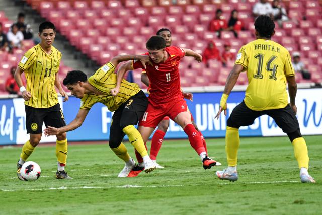 (261005) -- JAKARTA, Oct. 5, 2026 (Xinhua) -- Ubaidullah Shamsul  (2nd L) of Malaysia vies with Williams Minh Hoang (2nd R) of Vietnam during the FIFA ASEAN Cup 2026 Division 1 Bronze Final Match between Malaysia and Vietanm at Gelora Bung Karno Stadium in Jakarta, Indonesia, Oct. 5, 2026. (Xinhua/Agung Kuncahya B.)