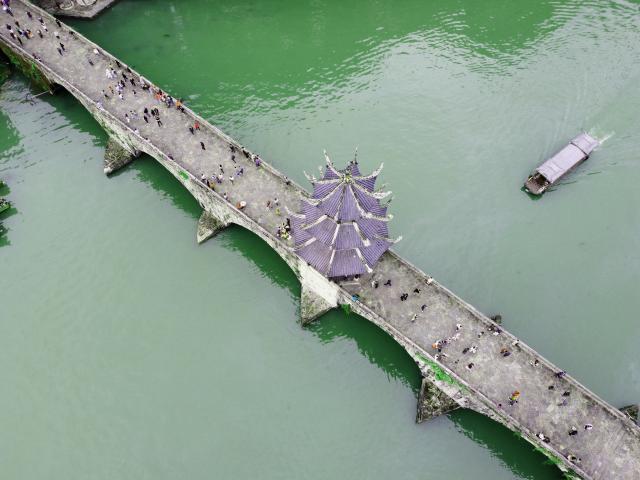 (261005) -- BEIJING, Oct. 5, 2026 (Xinhua) -- An aerial drone photo taken on Oct. 5, 2026 shows tourists visiting an ancient town in Zhenyuan County of Qiandongnan Miao and Dong Autonomous Prefecture, southwest China's Guizhou Province. Large numbers of visitors have flocked to rural areas across China during the National Day holiday. (Photo by Tai Shengzhi/Xinhua)