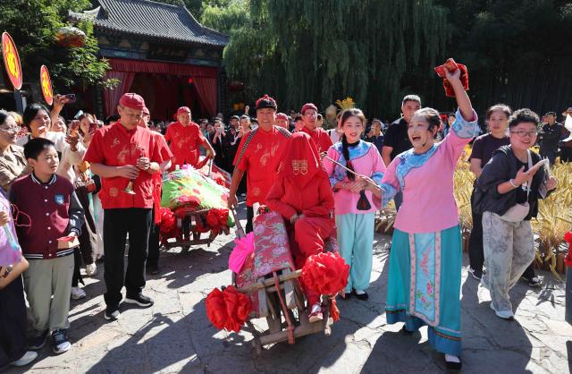 (261005) -- BEIJING, Oct. 5, 2026 (Xinhua) -- Tourists watch local folk performance in Yinan County, Linyi City, east China's Shandong Province, Oct. 5, 2026. Large numbers of visitors have flocked to rural areas across China during the National Day holiday. (Photo by Wang Yanbing/Xinhua)
