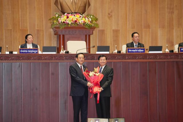 (261005) -- VIENTIANE, Oct. 5, 2026 (Xinhua) -- General Secretary of the Lao People's Revolutionary Party Central Committee and Lao President Thongloun Sisoulith (R, front) congratulates Sonexay Siphandone on being elected as president of the Lao National Assembly during the second ordinary session of the 10th Lao National Assembly in Vientiane, Laos, Oct. 5, 2026. The second ordinary session of the 10th Lao National Assembly elected Deputy Prime Minister Saleumxay Kommasith as prime minister, and elected Sonexay Siphandone, former prime minister, as President of the Lao National Assembly on Monday. (Lao News Agency/Handout via Xinhua)
