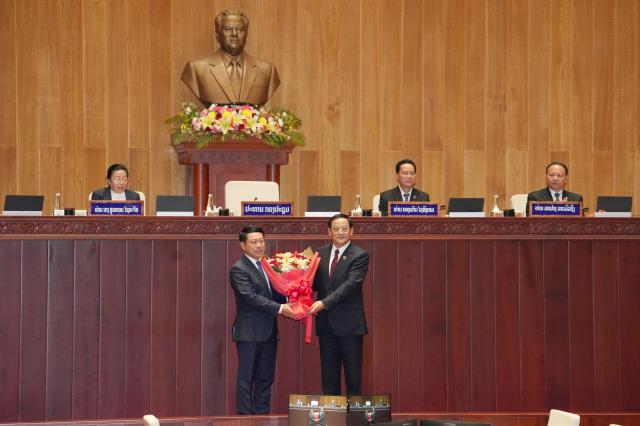 (261005) -- VIENTIANE, Oct. 5, 2026 (Xinhua) -- Newly elected President of the Lao National Assembly Sonexay Siphandone (R, front) congratulates Saleumxay Kommasith on being elected as prime minister during the second ordinary session of the 10th Lao National Assembly in Vientiane, Laos, Oct. 5, 2026. The second ordinary session of the 10th Lao National Assembly elected Deputy Prime Minister Saleumxay Kommasith as prime minister, and elected Sonexay Siphandone, former prime minister, as President of the Lao National Assembly on Monday. (Lao News Agency/Handout via Xinhua)