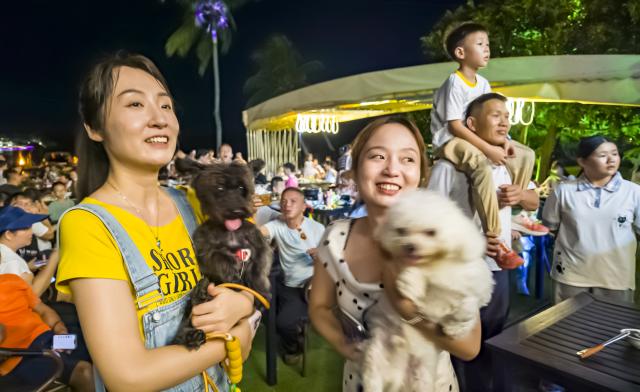 (261006) -- BEIJING, Oct. 6, 2026 (Xinhua) -- People watch a show at a scenic spot featuring tropical fruits in Qionghai, south China's Hainan Province, Oct. 4, 2026. During the National Day holiday, night tours were launched across China to create diversified consumption scenes. (Photo by Meng Zhongde/Xinhua)