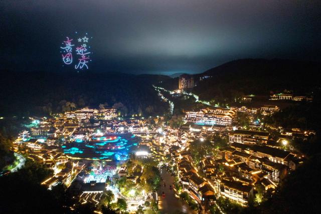 (261006) -- BEIJING, Oct. 6, 2026 (Xinhua) -- An aerial drone photo taken on Oct. 2, 2026 shows people watching a drone light show at Wujiangzhai scenic spot in Zunyi, southwest China's Guizhou Province. During the National Day holiday, night tours were launched across China to create diversified consumption scenes. (Photo by Li Renjun/Xinhua)